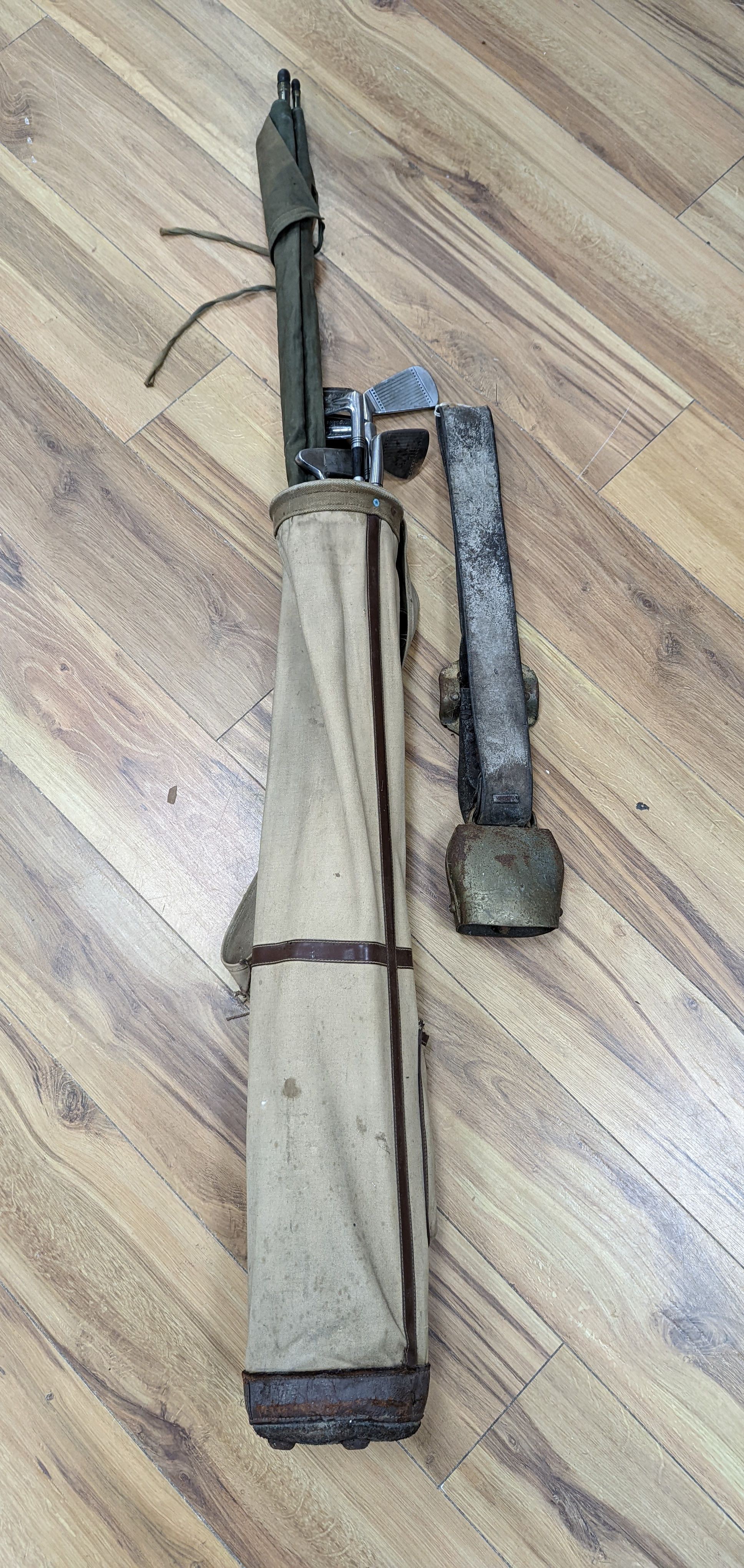 A split cane fishing rod, quantity of golf clubs, cows bell